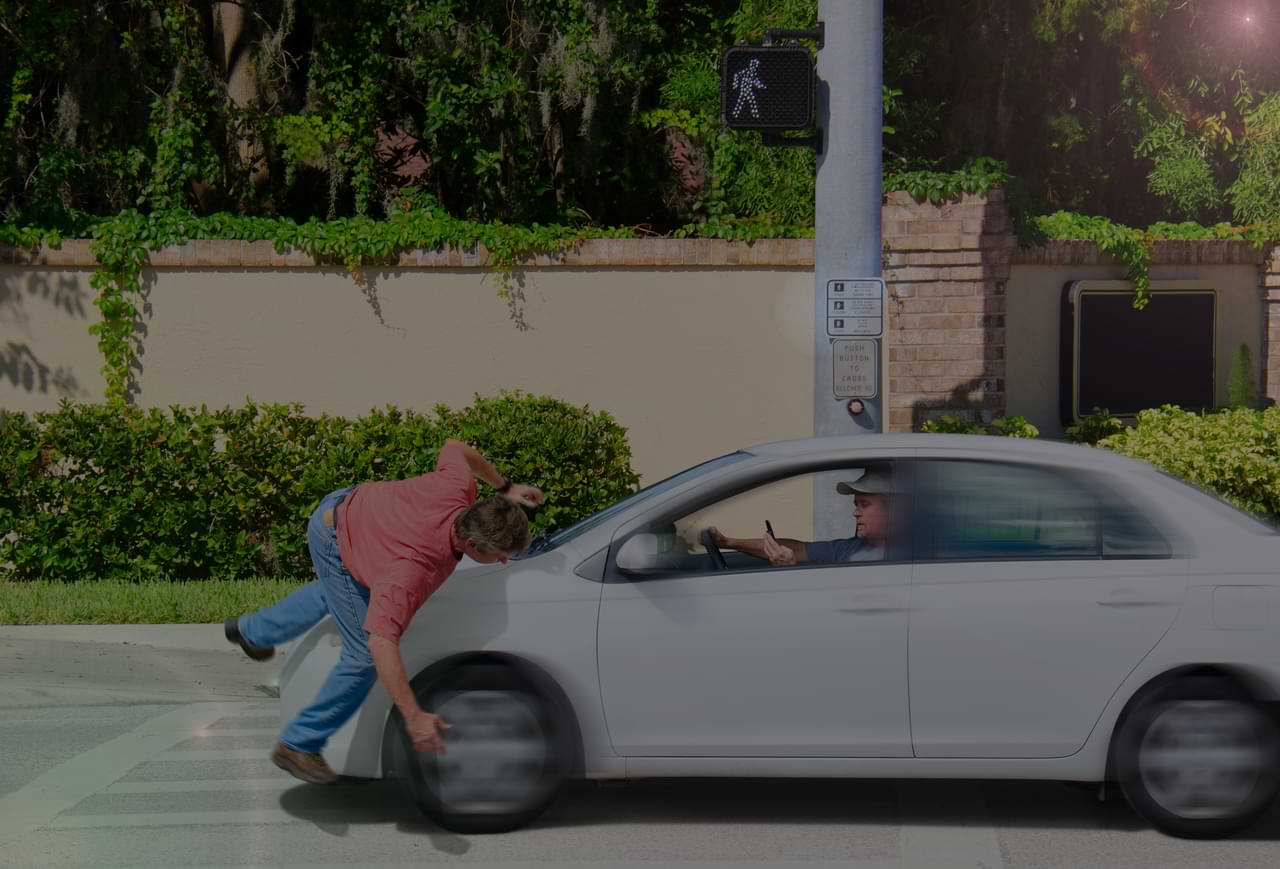 Pedestrian accident scene with a man being struck by a car while crossing at a traffic signal, highlighting pedestrian safety and legal implications.